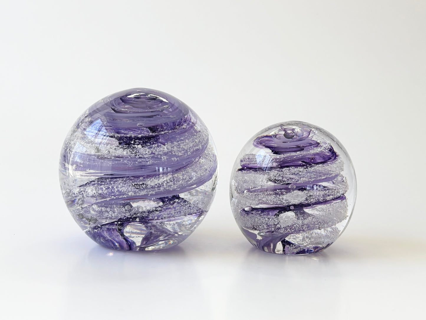 Handblown glass keepsake in mini size and ashes in purple side by side size comparison