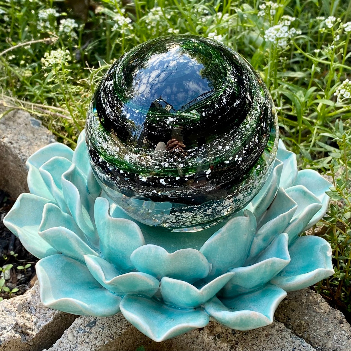 molten glass infused with pet ashes for a custom memorial in black and green sparkle