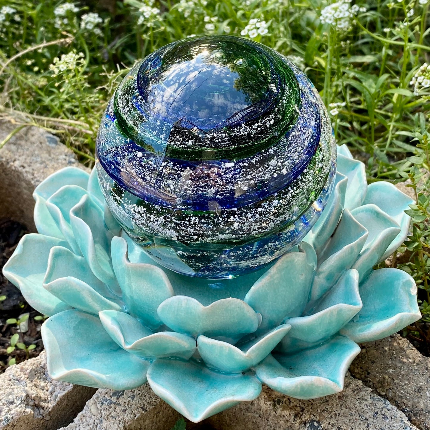 Fine cremains suspended in clear and colored glass, creating a unique tribute blue and green sparkle