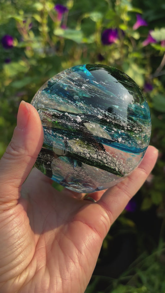 Handblown glass memorial orb with green sparkling swirl, aquamarine and cremation ashes