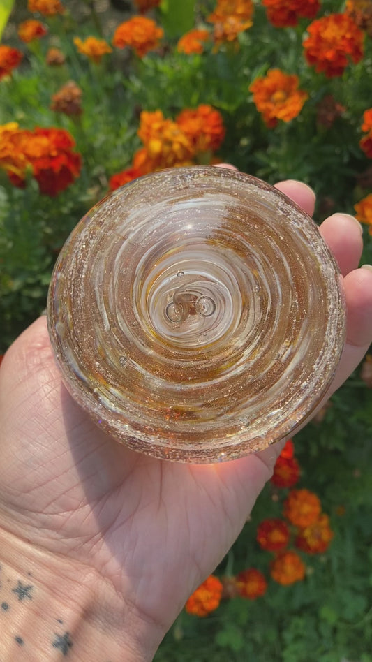 Beautiful swirl of cremains infused into a pet memorial glass paperweight in gold sparkle and white