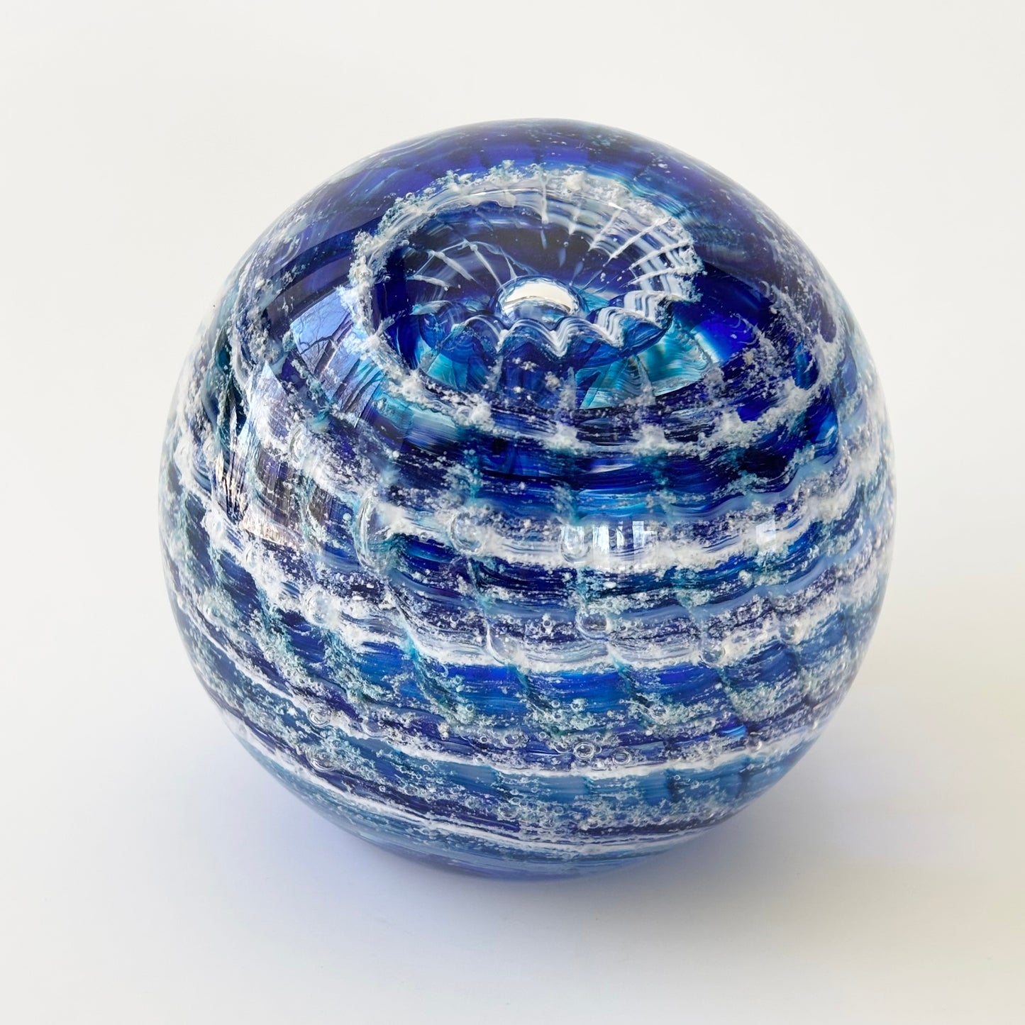 Cremation art sphere with swirling color and ashes, hand-blown in a ripple optic design