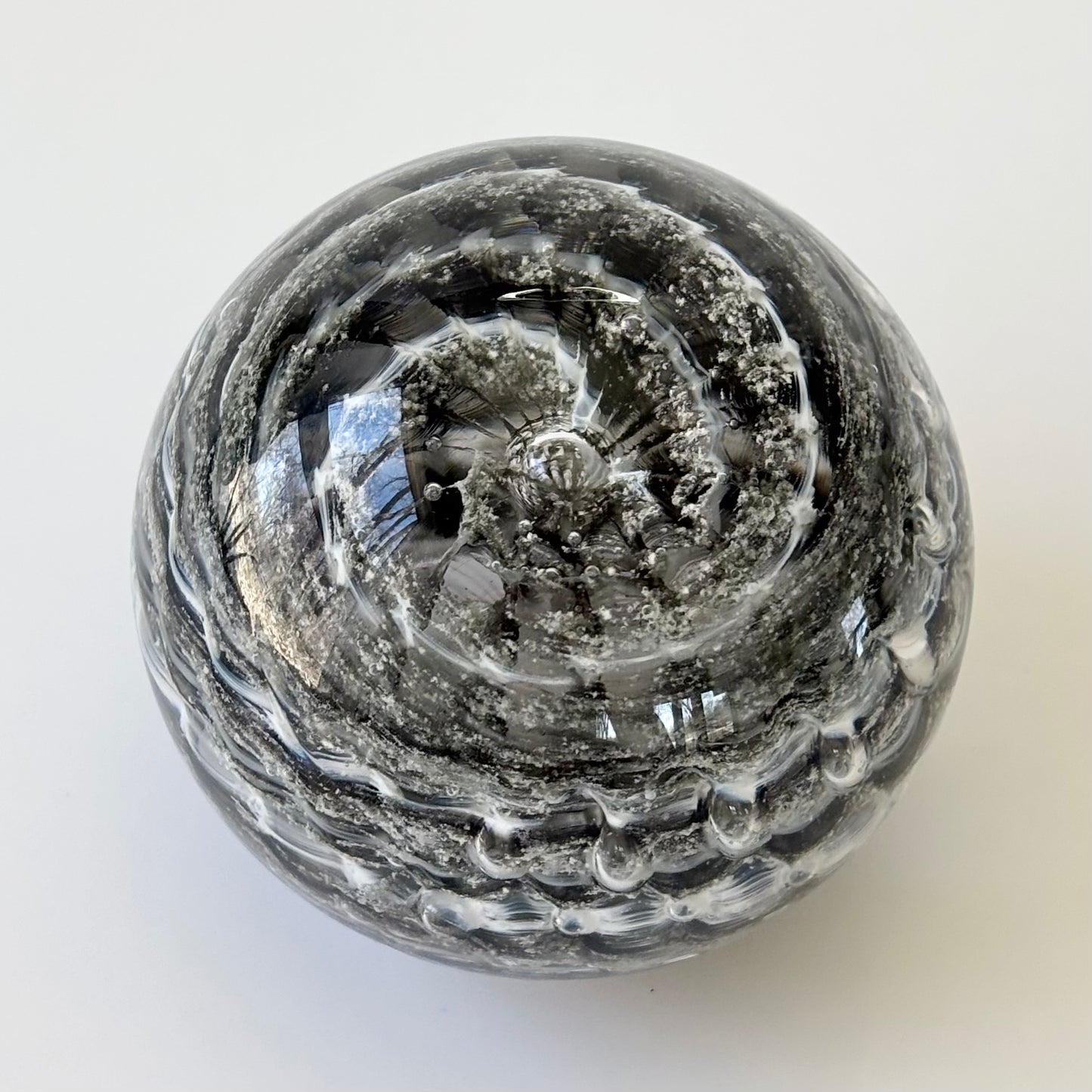 Artistic cremation memorial orb made with infused ashes and textured ripple color design

