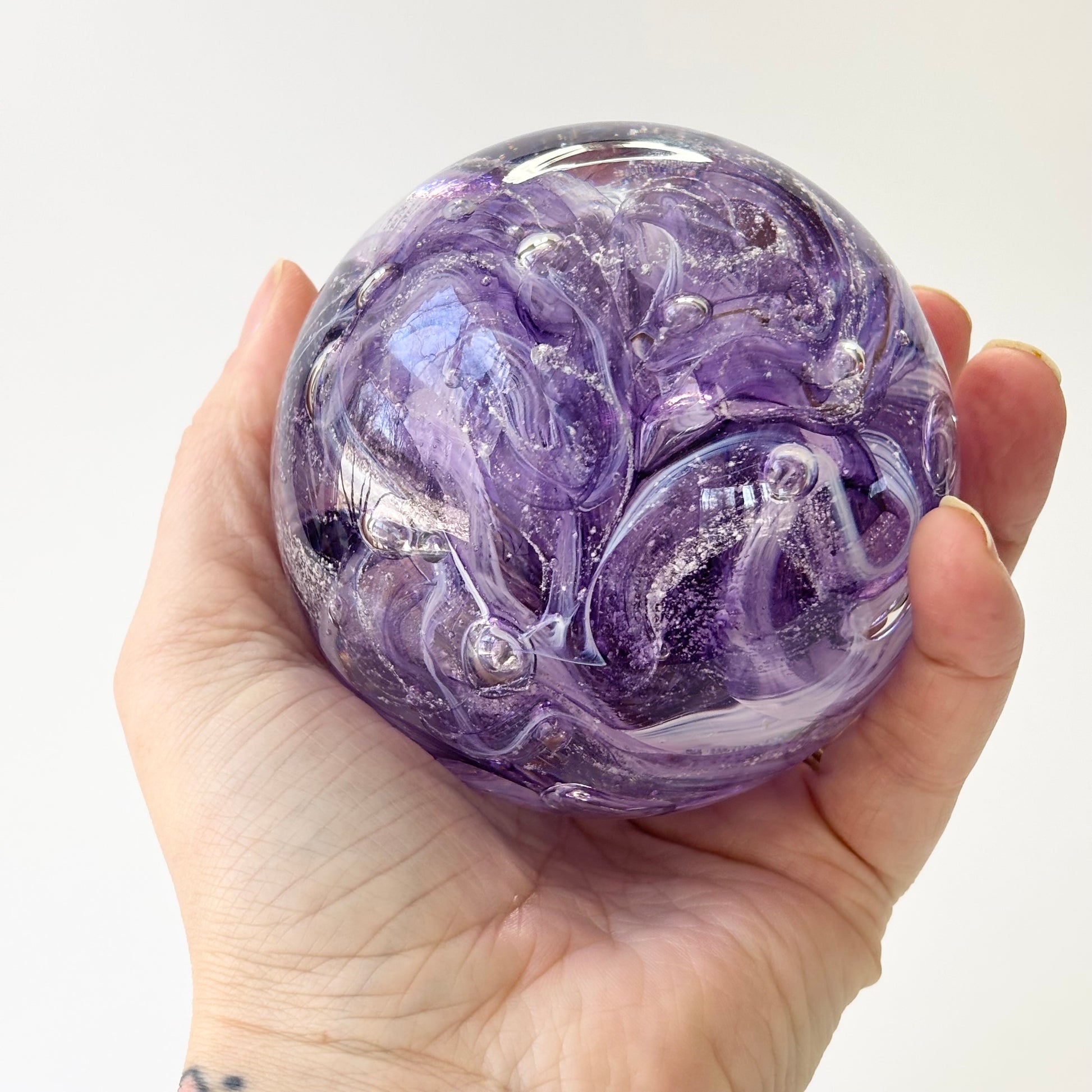 Ash-infused blown glass keepsake with purple and white swirls and luminous texture
