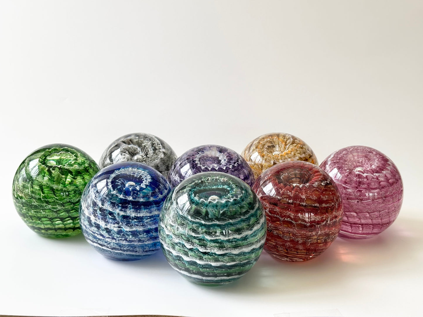 Glass remembrance orb with swirling ash and ridged ripple design, ideal for heartfelt memorial