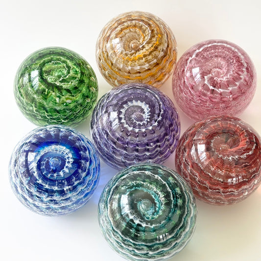 Ash-infused ripple memorial glass orb made by hand with custom color swirls and optic detail
