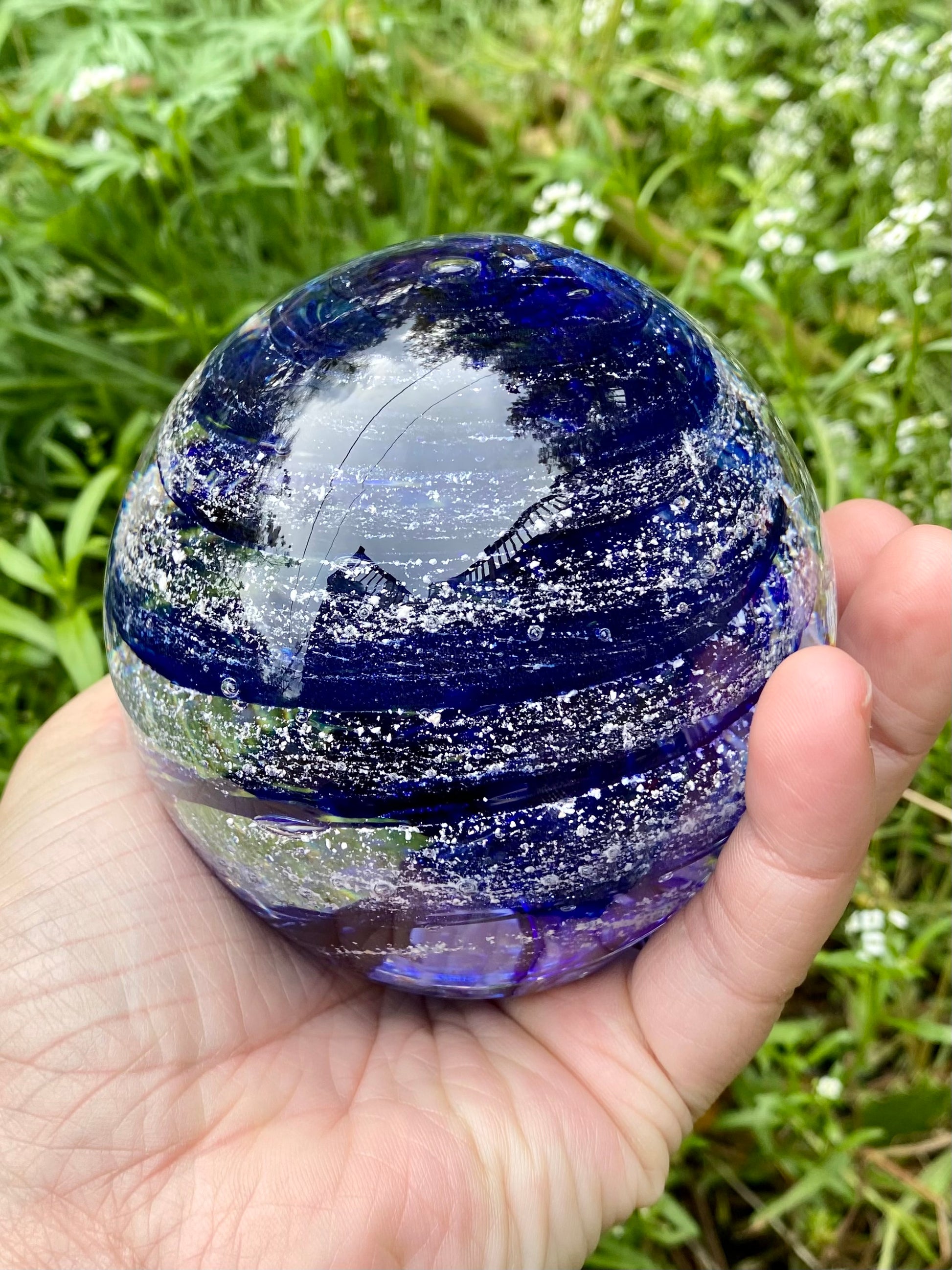 Close-up of cremation ashes infused into a glass pet memorial keepsake with cobalt blue sparkle 