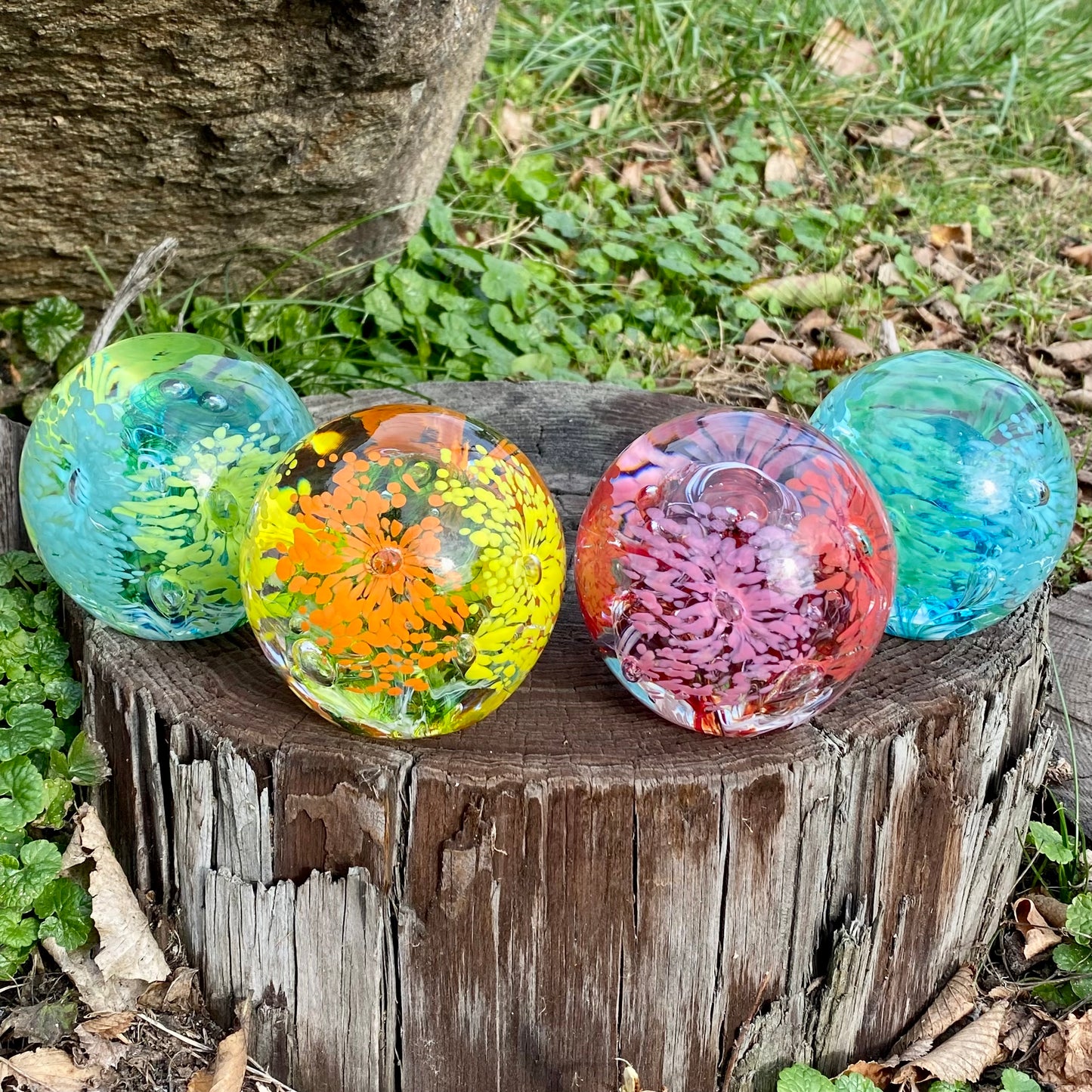 Detailed view of Eternal Garden glass orb showing hand-pulled flower petals surrounding swirling core custom colors