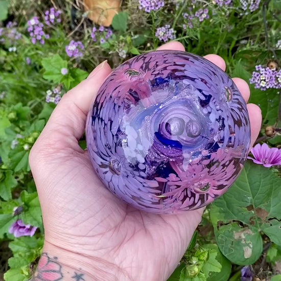 Eternal garden memorial orb. Glass paperweight with pink and purple flowers, ashes swirled in the center 