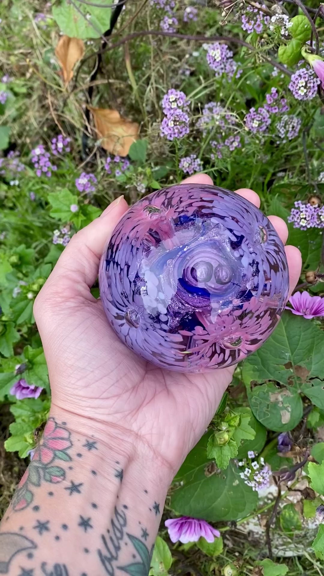 Eternal garden memorial orb. Glass paperweight with pink and purple flowers, ashes swirled in the center 