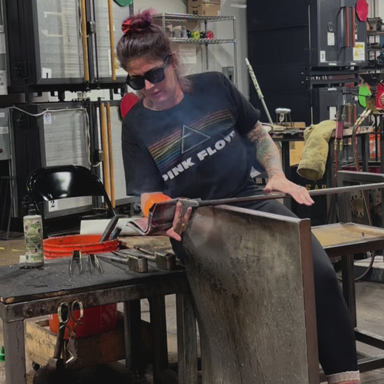 In the glass studio shaping molten glass and infused ashes. 